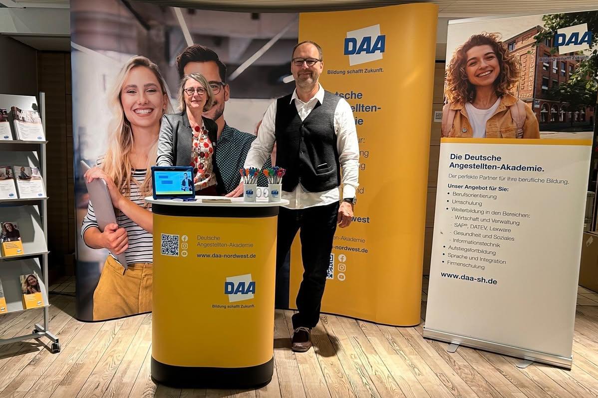 Zwei Mitarbeiter im gelben Messestand der DAA Neumünster